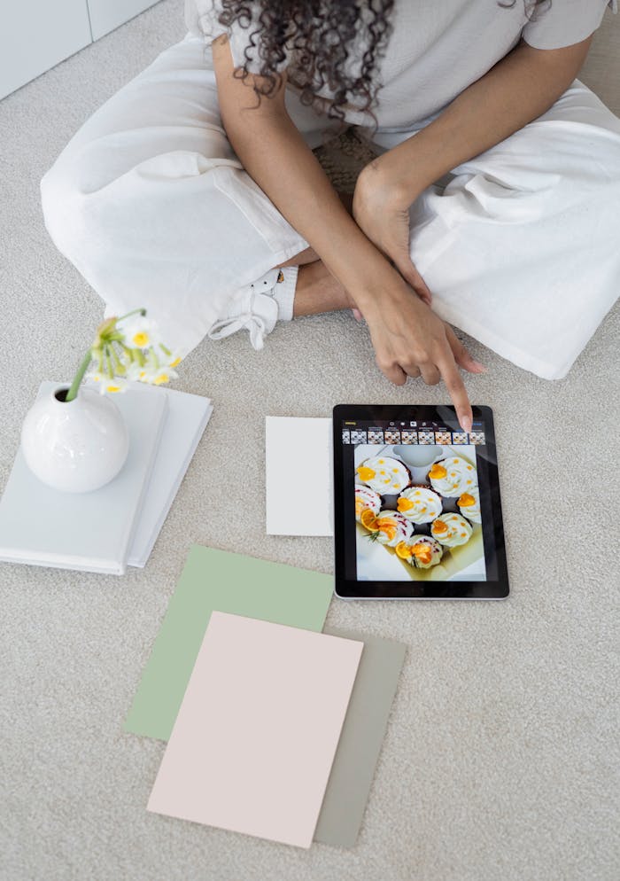 Young woman using a tablet in a modern, minimalist workspace with pastel decor.